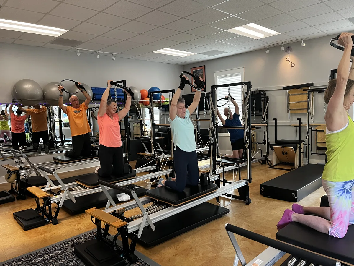 Full group Pilates class at Dancing Hammock — clients on Reformer and Tower equipment