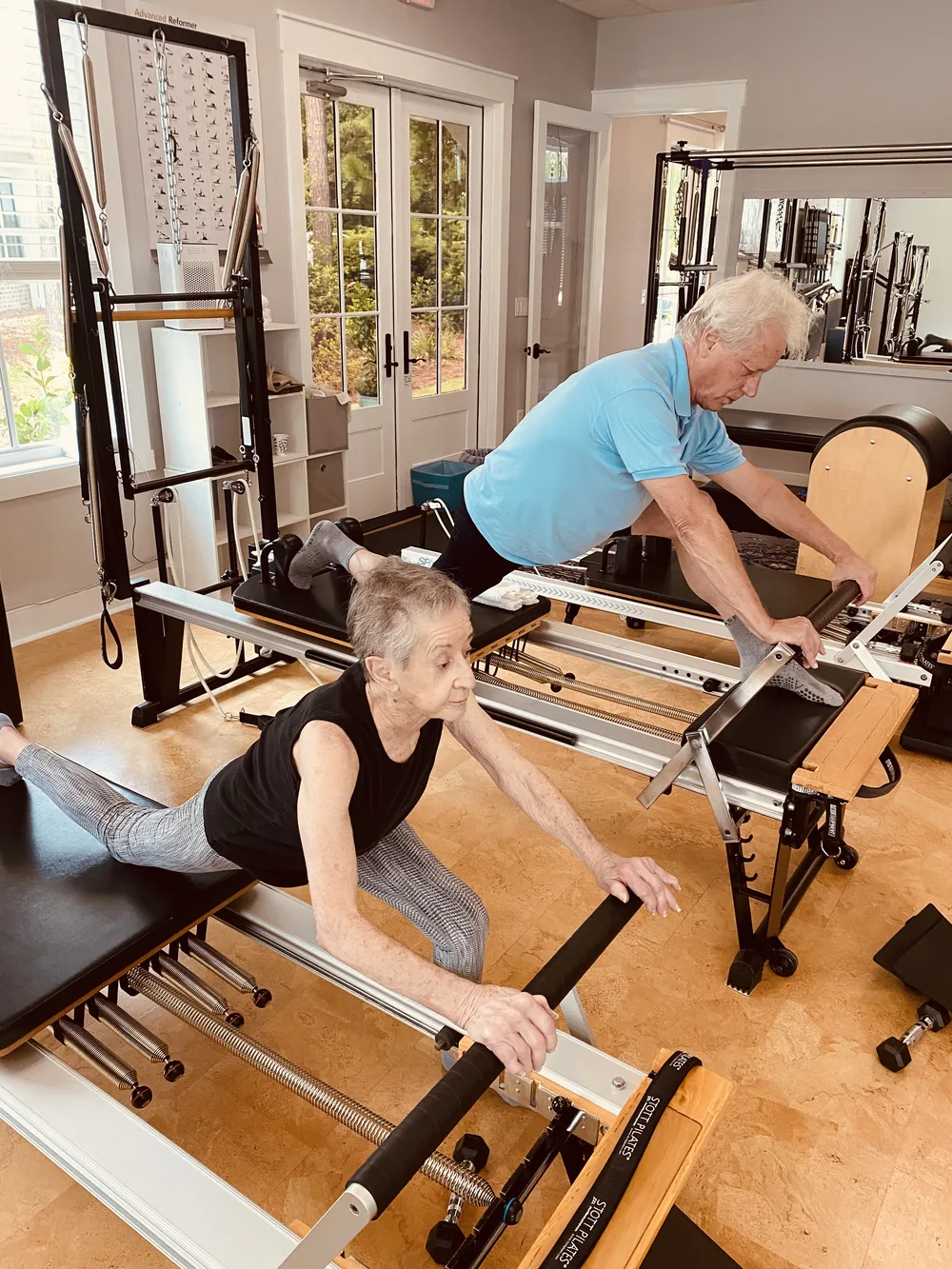 Couple working together on Pilates Reformers at Dancing Hammock studio